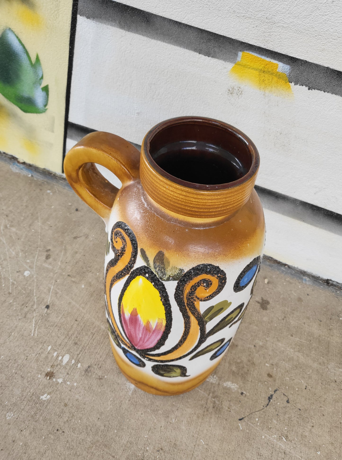 Side view of tall handled West German floor vase, mid-century ceramic with bold floral design