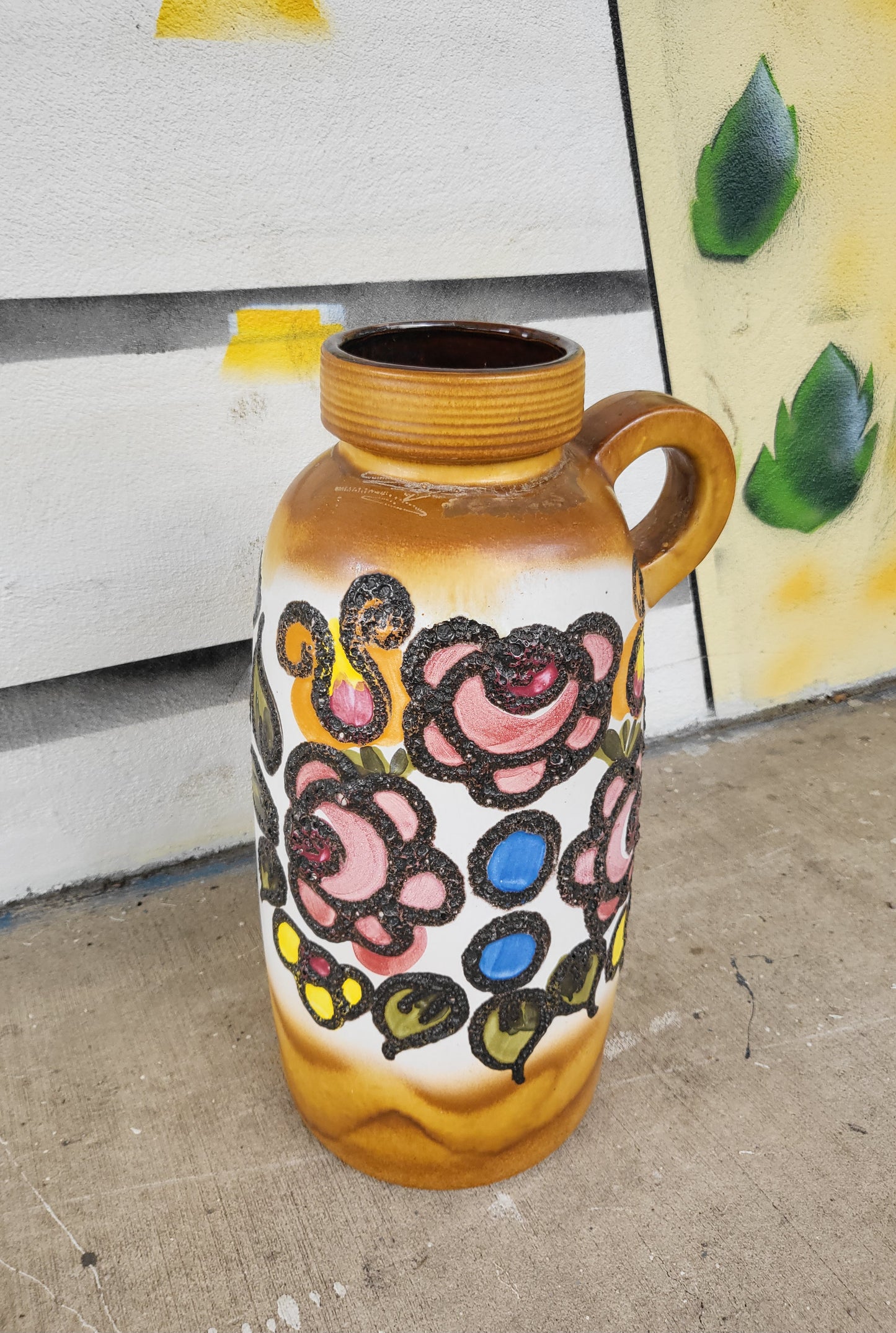 Close-up of raised floral motifs on vintage West German pottery vase