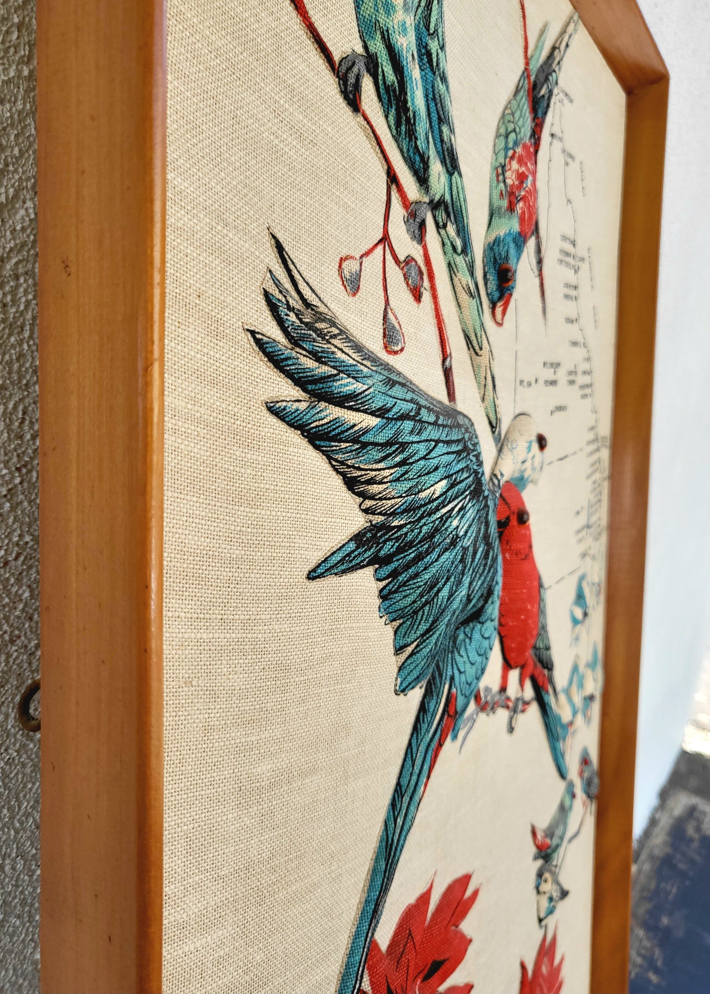Close-up of raised padded textile artwork showing Australian parrots and floral details