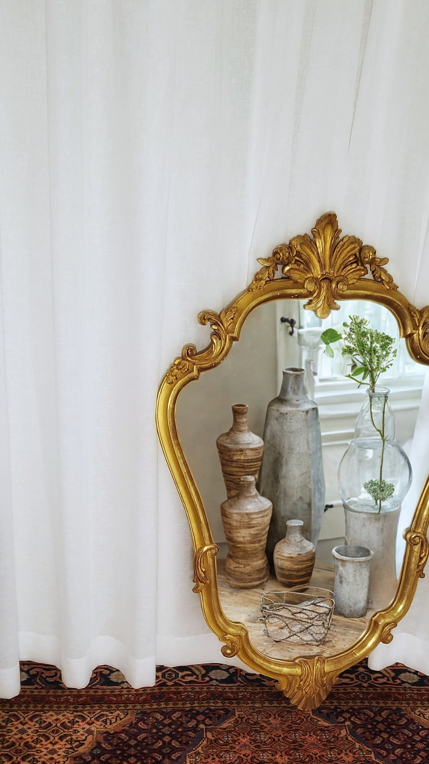 Antique French Rococo gilt mirror with floral crest and ornate scrollwork