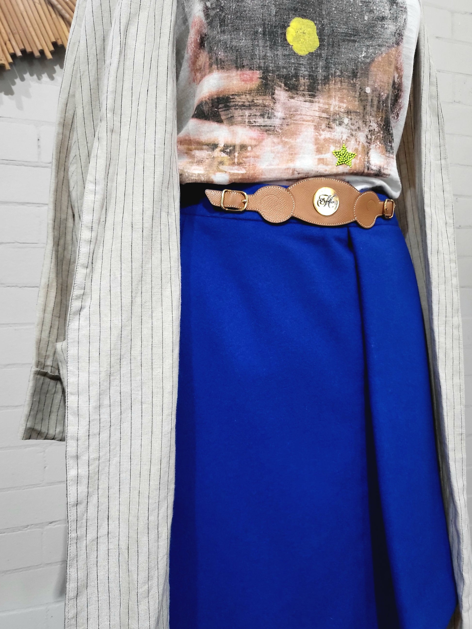 Side view of vintage Hermès cobalt blue wrap skirt showing sculptural drape and leather waist