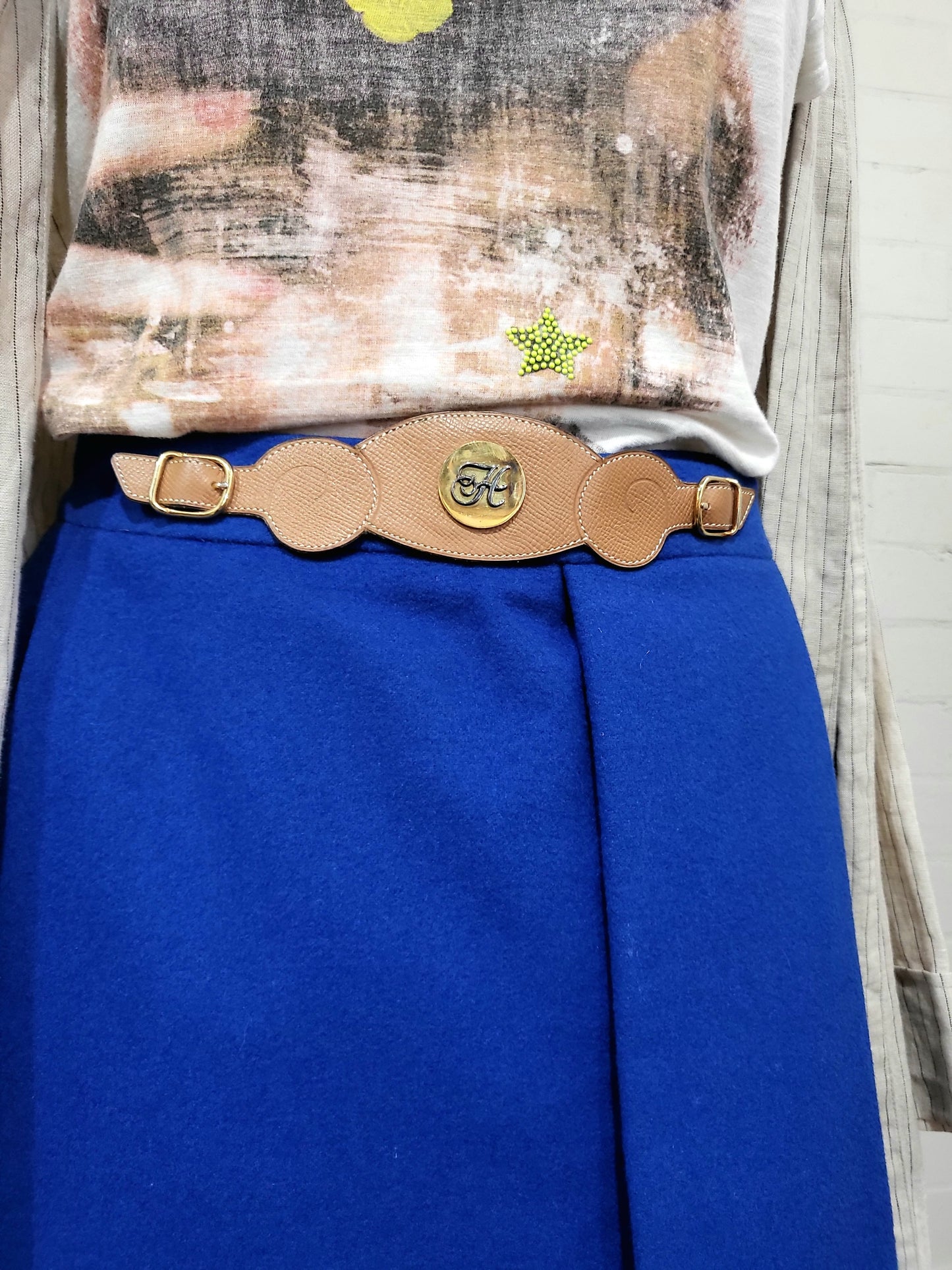 Side view of vintage Hermès cobalt blue wrap skirt showing sculptural drape and leather waist