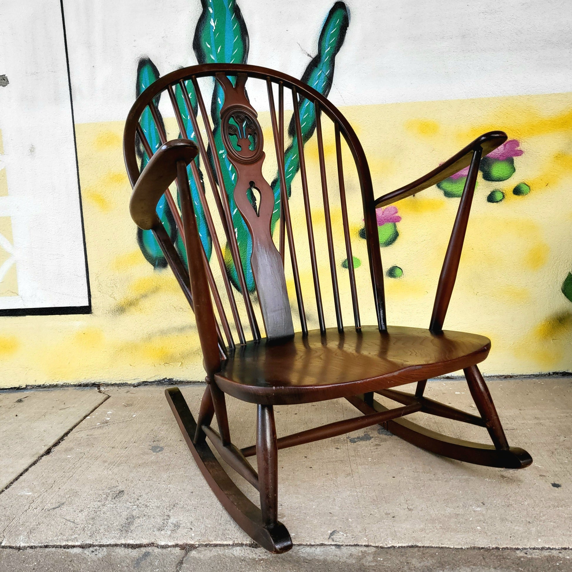 1960s Ercol Prince of Wales rocking chair with high spindle back and curved armrests, crafted from solid elm and beech, shown on polished concrete floor.