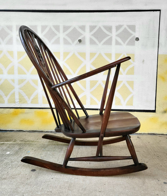 Side view of vintage Ercol rocking chair with curved runners and sculpted seat, showcasing mid-century design craftsmanship.