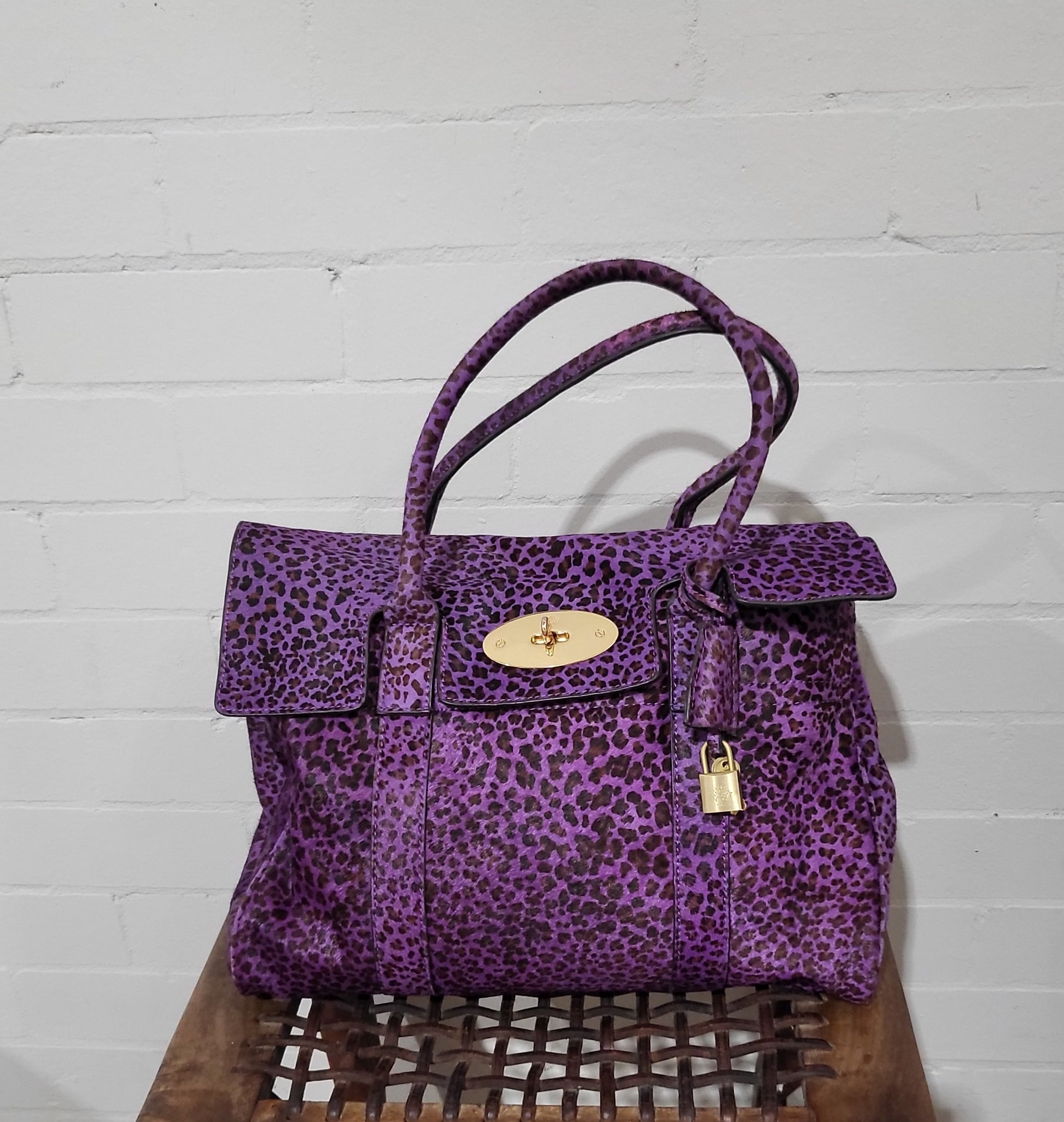 Front view of Mulberry Bayswater bag in purple leopard-print pony hair with gold postman’s lock closure.