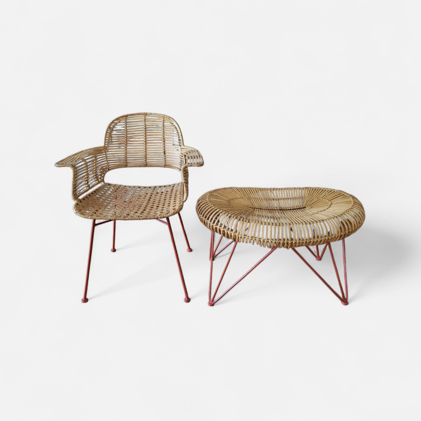 1960s Swedish Scandinavian modern rattan armchair and matching oval ottoman with red metal legs.