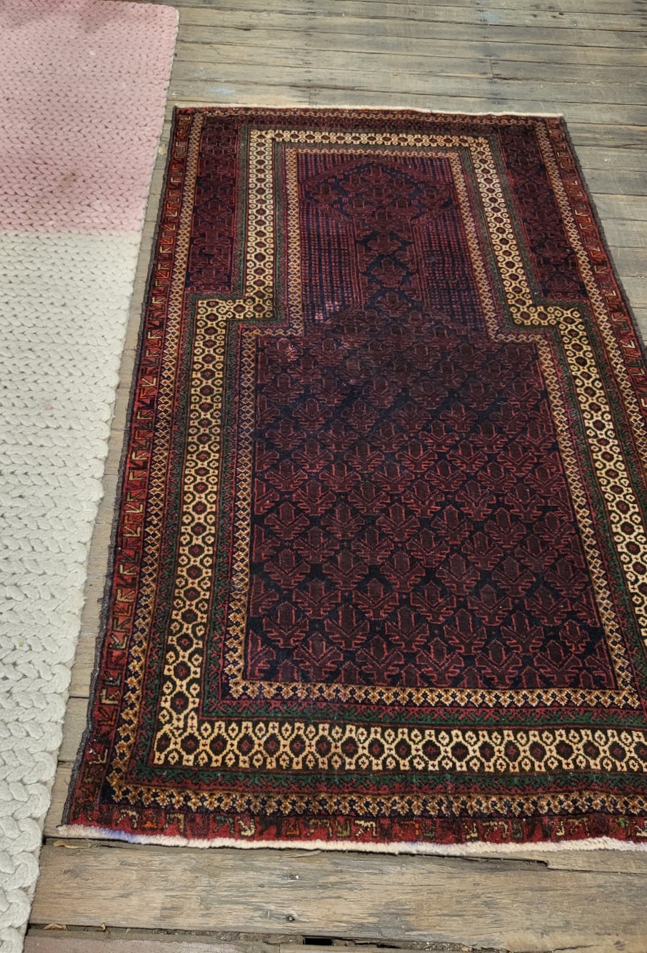 Vintage Persian Balouchi handwoven wool rug in deep purple and red tones with intricate tribal geometric patterns, 158 x 92 cm.